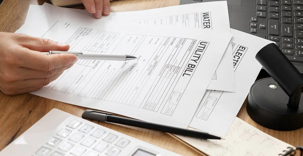 Utility bills and pricing documents being reviewed as part of a business electricity contract comparison.